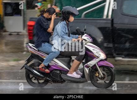 SAMUT PRAKAN, THAILANDIA, 21 2022 SETTEMBRE, due donne guidano moto sotto la pioggia Foto Stock