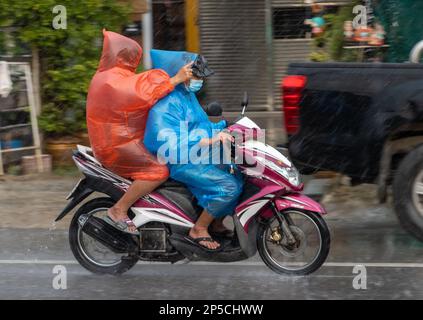 SAMUT PRAKAN, THAILANDIA, 21 2022 SETTEMBRE, coppia in impermeabile guidare sotto la pioggia Foto Stock