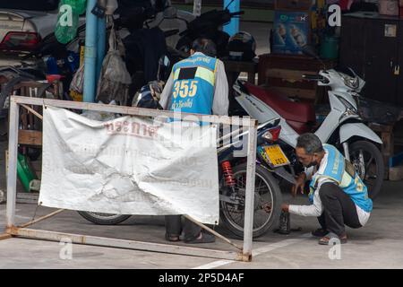 SAMUT PRAKAN, THAILANDIA, 17 2023 FEBBRAIO, Mototaxi piloti riparare moto presso la stazione dei taxi Foto Stock