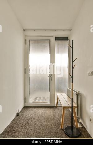 una stanza vuota con due porte e una panca al centro di una porta è aperta, mentre le altre sono chiuse Foto Stock