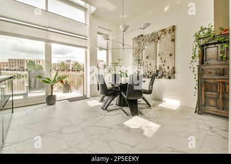 un soggiorno con pavimento in marmo bianco e grandi finestre che si affacciano sulla vista della citta' Foto Stock