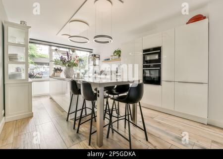 Moderna cucina con isola centrale e sgabelli bar con moderni cabinetry e  gli elettrodomestici in folle sfumature di marrone e beige Foto stock -  Alamy