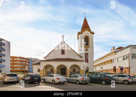 e' visibile una piccola cittadina con auto parcheggiate davanti ad essa e un orologio sul lato dell'edificio Foto Stock