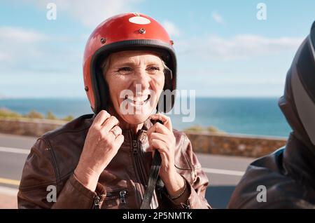 Estate, donna anziana e casco sulla strada, felicità e tempo di qualità in pausa, relax e vacanza. Donna matura, donna anziana e sicurezza per moto Foto Stock