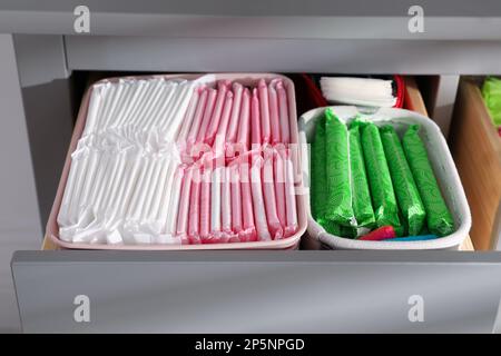 Cassetto a armadio aperto con tamponi mestruali, tamponi e pantiline, primo piano Foto Stock