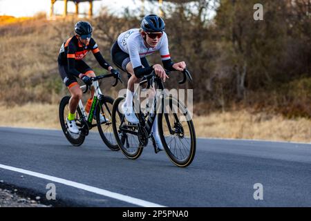 Due ciclisti guidano le loro biciclette lungo una strada tortuosa, godendosi il paesaggio e l'aria fresca durante il Cedar Hill Race Festival Foto Stock