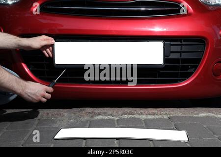 Numero dell'auto senza lettere e numeri sul paraurti dell'auto targa bianca  vuota davanti all'auto tutti i loghi rimossi da vicino la targa  rettangolare anteriore di un veicolo sulla strada