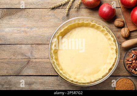 Composizione di posa piatta con pasta cruda e ingredienti su tavolo di legno, spazio per testo. Torta di mele in forno Foto Stock