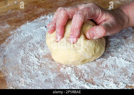 Impastare a mano la pasta cruda Foto Stock