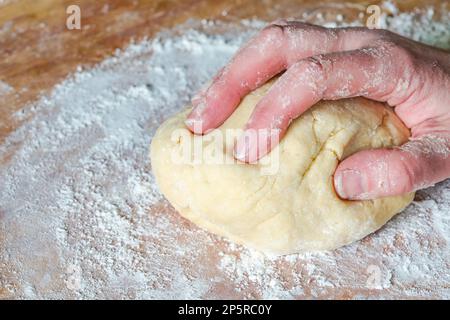 Impastare a mano la pasta cruda Foto Stock