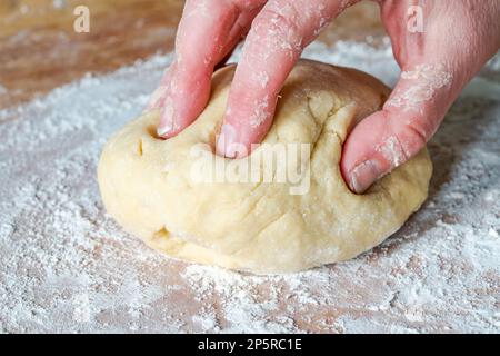 Impastare a mano la pasta cruda Foto Stock