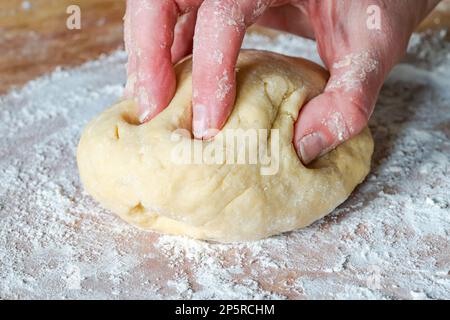 Impastare a mano la pasta cruda Foto Stock