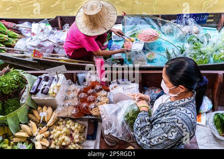 I thailandesi mangiano su una barca a coda lunga al Lad Mayom Floating Market, Bangkok, Thailandia Foto Stock