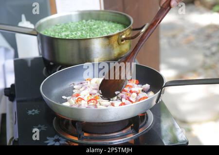 Preparazione delle verdure in stufa, sauting cipolla e fagiolini bollenti Foto Stock