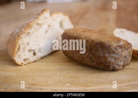 polpettone di manzo con una pagnotta di pane dietro Foto Stock