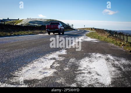 Queensbury, West Yorkshire, Regno Unito. 7th marzo, 2023. Meteo nel Regno Unito. Un inizio freddo gelido della giornata nelle colline Pennine di Queensbury, West Yorkshire con una polvere di neve leggera e ghiaccio che rendono le condizioni pericolose per gli escursionisti di cani, joggers e auto escursionisti. Credit: Windmill Images/Alamy Live News Foto Stock