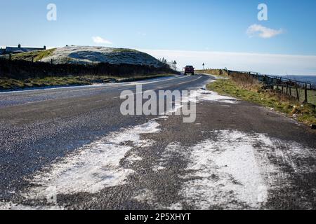 Queensbury, West Yorkshire, Regno Unito. 7th marzo, 2023. Meteo nel Regno Unito. Un inizio freddo gelido della giornata nelle colline Pennine di Queensbury, West Yorkshire con una polvere di neve leggera e ghiaccio che rendono le condizioni pericolose per gli escursionisti di cani, joggers e auto escursionisti. Credit: Windmill Images/Alamy Live News Foto Stock