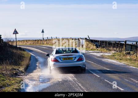 Queensbury, West Yorkshire, Regno Unito. 7th marzo, 2023. Meteo nel Regno Unito. Un inizio freddo gelido della giornata nelle colline Pennine di Queensbury, West Yorkshire con una polvere di neve leggera e ghiaccio che rendono le condizioni pericolose per gli escursionisti di cani, joggers e auto escursionisti. Credit: Windmill Images/Alamy Live News Foto Stock