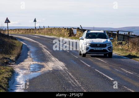 Queensbury, West Yorkshire, Regno Unito. 7th marzo, 2023. Meteo nel Regno Unito. Un inizio freddo gelido della giornata nelle colline Pennine di Queensbury, West Yorkshire con una polvere di neve leggera e ghiaccio che rendono le condizioni pericolose per gli escursionisti di cani, joggers e auto escursionisti. Credit: Windmill Images/Alamy Live News Foto Stock