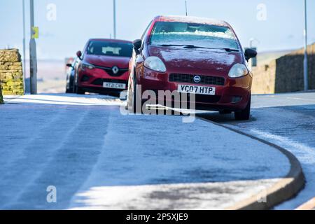 Queensbury, West Yorkshire, Regno Unito. 7th marzo, 2023. Meteo nel Regno Unito. Un inizio freddo gelido della giornata nelle colline Pennine di Queensbury, West Yorkshire con una polvere di neve leggera e ghiaccio che rendono le condizioni pericolose per gli escursionisti di cani, joggers e auto escursionisti. Credit: Windmill Images/Alamy Live News Foto Stock