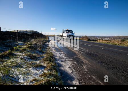 Queensbury, West Yorkshire, Regno Unito. 7th marzo, 2023. Meteo nel Regno Unito. Un inizio freddo gelido della giornata nelle colline Pennine di Queensbury, West Yorkshire con una polvere di neve leggera e ghiaccio che rendono le condizioni pericolose per gli escursionisti di cani, joggers e auto escursionisti. Credit: Windmill Images/Alamy Live News Foto Stock