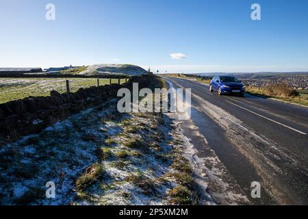 Queensbury, West Yorkshire, Regno Unito. 7th marzo, 2023. Meteo nel Regno Unito. Un inizio freddo gelido della giornata nelle colline Pennine di Queensbury, West Yorkshire con una polvere di neve leggera e ghiaccio che rendono le condizioni pericolose per gli escursionisti di cani, joggers e auto escursionisti. Credit: Windmill Images/Alamy Live News Foto Stock