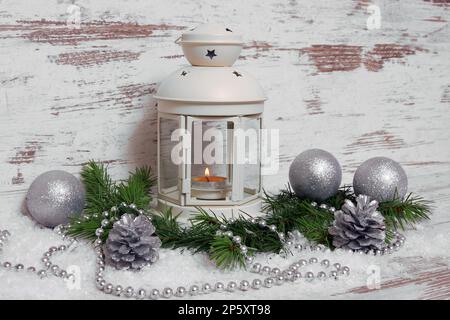 Decorazione natalizia, lanterna con baubles, rami di abete, coni di pino, neve artificiale e cappelletto Foto Stock