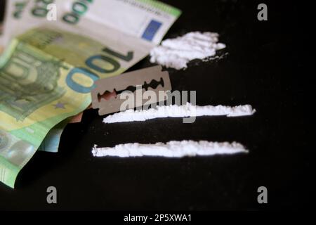 Linee di cocaina, lama Razor e 100 Euro Nota Foto Stock