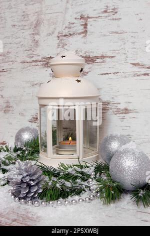 Decorazione natalizia, lanterna con baubles, rami di abete, coni di pino, neve artificiale e cappelletto Foto Stock