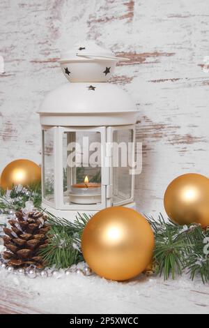 Decorazione natalizia, lanterna con baubles, rami di abete, coni di pino, neve artificiale e cappelletto Foto Stock