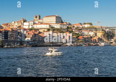 Vista su Porto da Vila Nova de Gaia, con il fiume Douro in primo piano e il molo lungo il fiume, le case e la Cattedrale sullo sfondo, Foto Stock