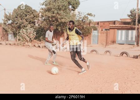 Ouagadougou, Burkina Faso. Alcuni uomini stanno giocando una partita di calcio in un sobborgo della capitale Foto Stock