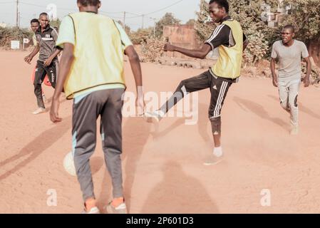 Ouagadougou, Burkina Faso. Alcuni uomini stanno giocando una partita di calcio in un sobborgo della capitale Foto Stock