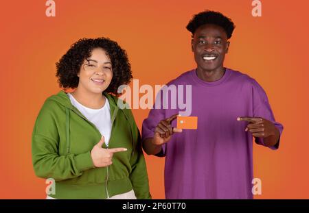 Felici amanti di gara mista mostrando carta di credito Foto Stock