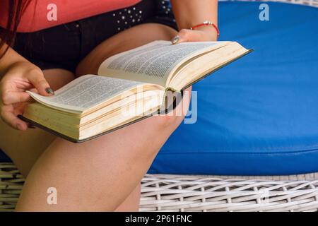 mani femminili che tengono vecchio libro, donna irriconoscibile seduta lettura, spazio di copia, concetto di letteratura Foto Stock