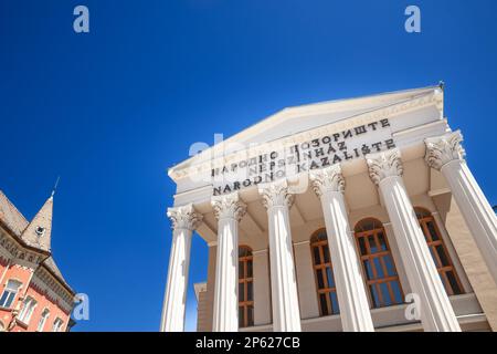 Foto di Narodno Pozoriste, o Teatro Nazionale, scattata durante un pomeriggio soleggiato con persone che passano di fronte. Il Teatro Nazionale è un teatro di S. Foto Stock