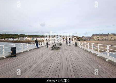 Turisti sullo storico molo di Beaumaris con vista che guarda indietro verso la città, Anglesey, Galles del Nord. Foto Stock