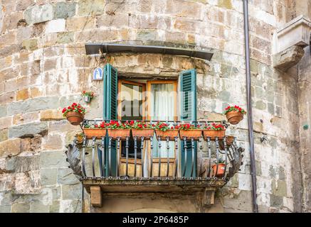 Pittoresco balcone con decorazioni floreali nella città di Lucca, Toscana, Italia centrale, Europa Foto Stock