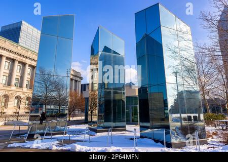 Cleveland, Ohio, USA - 24 gennaio 2023: La neve copre l'erba in un parco con strutture a specchio che riflettono l'ambiente circostante in una fredda giornata invernale Foto Stock