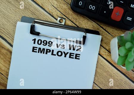 Concetto di 1099 vs W2 Employee scrivere su documenti isolati su tavola di legno. Foto Stock