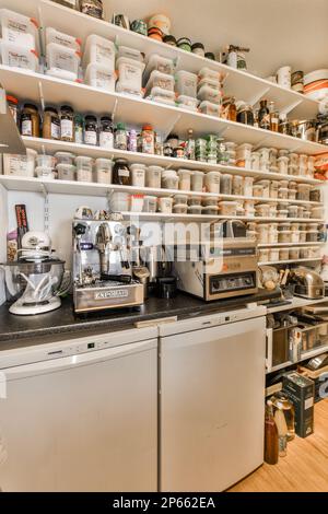 una cucina con molti pentole e padelle sul ripiano sopra la lavastoviglie che si trova di fronte al piano cottura Foto Stock