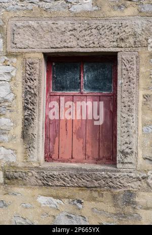 Una vecchia finestra di legno rosso sbiadita in un granaio del Derbyshire, Inghilterra Foto Stock