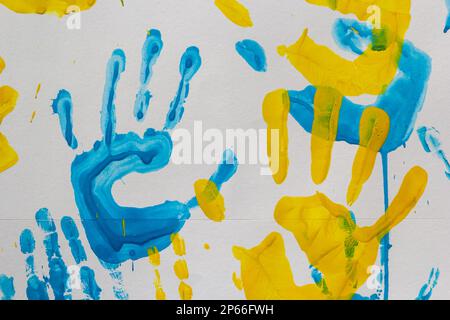 stampe luminose delle mani dei bambini da pittura sulla parete, sullo sfondo, sulla trama, sul formato orizzontale. Foto Stock