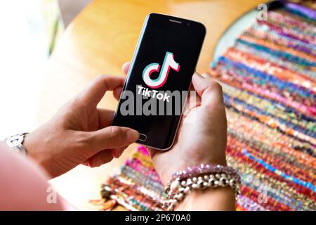 Tiktok sullo schermo del telefono cellulare. Giovane donna che tiene in mano uno smartphone con l'app Tik Tok. Miami, FL, Stati Uniti -29 GENNAIO 2022. Foto Stock