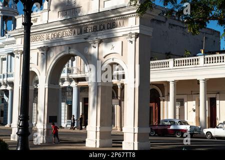 Arco commemorativo del Parque Jose Marti in luce del mattino applitto, ragazzo in rosso che gioca a nascondino e cercare, Cienfuegos, UNESCO, Cuba, Indie Occidentali, Caraibi Foto Stock
