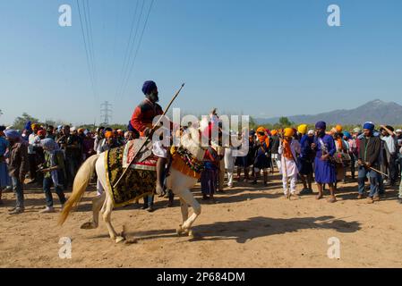 Un sikh cavalca a cavallo durante Hola Moholla ad Anandpur Sahib in Punjab Foto Stock