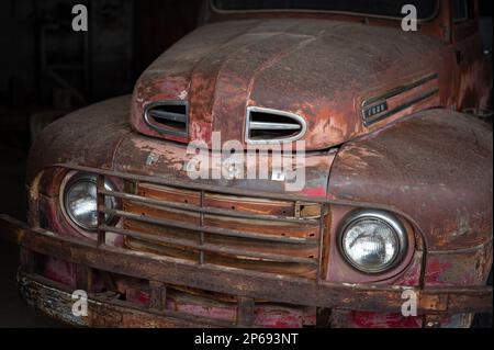 Vecchia officina meccanica abbandonata sulla strada del deserto. All'interno c'è un vecchio pick-up Ford F-1. Foto Stock