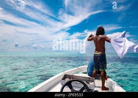 Uomo da dietro guardando la vista durante un'escursione in barca, Maldive Foto Stock