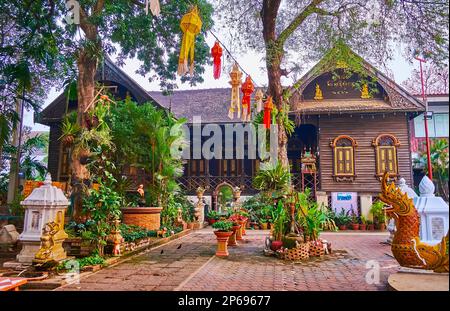 Il giardino verde di Wat Ket Karam con lanterne Lanna colorate, fiori in pentole e statue di serpenti Naga, Chiang mai, Thailandia Foto Stock