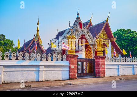 La porta del tempio di Wat Buppharam è decorata con colonne di leoni dorati, Chiang mai, Thailandia Foto Stock